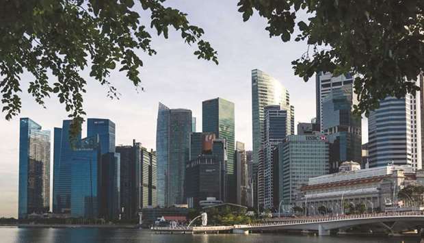 The Merlion Statue and Jubilee Bridge stand in front of the city skyline in Singapore. The Asian country plans to rein in its budget deficit as the economy recovers, while digging deeper into government reserves for a new $8.3bn package to help households and businesses rebound from the Covid-19 pandemic.