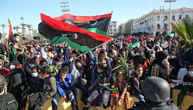 Libyans wave national flags as they gather in the capital Tripoliu2019s Martyru2019s Square to celebrate the 10th anniversary of the 2011 revolution, yesterday.