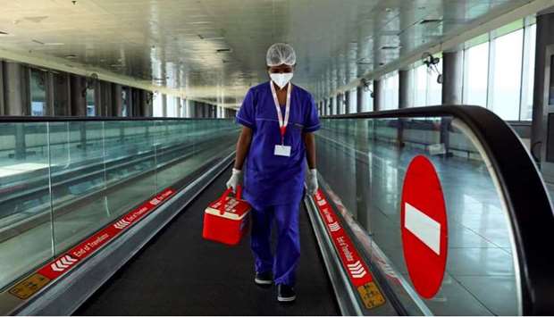 A laboratory technician carries swab samples collected from passengers amidst the spread of the coronavirus disease (Covid-19) at Indira Gandhi International Airport, in New Delhi, India
