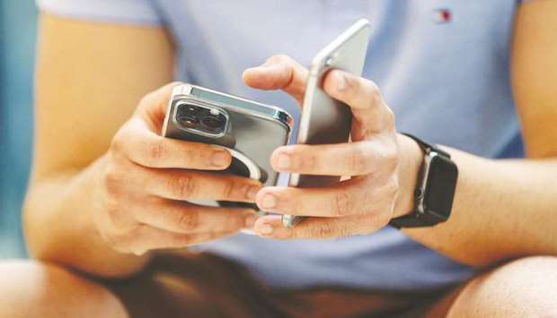 A customer checks an iPhone 12 Pro Max at an Apple flagship store in Sydney, Australia. The new battery pack Apple is developing would attach to the back of an iPhone 12 using the MagSafe system, which all the new phones use for charging and pairing other accessories like cases and wallets.