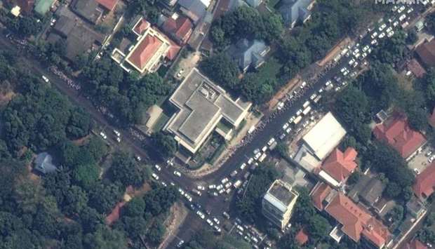 This handout satellite image released by Maxar Technologies shows lines of people outside the American Center in Yangon, Myanmar yesterday.