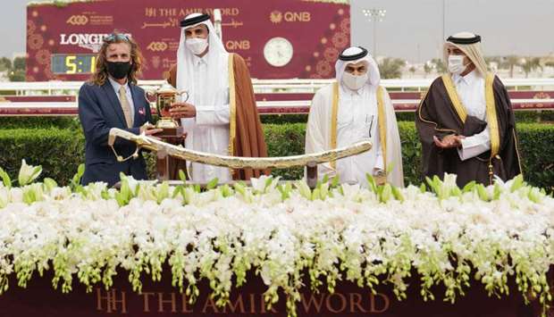 His Highness The Amir Sheikh Tamim bin Hamad al-Thani presents the trainer's trophy to Julian Smart (left) after Mon'nia won His Highness The Amir Sword (Group 1 PA)