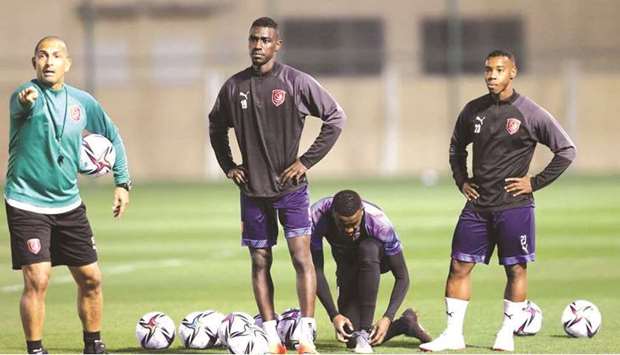Al Duhailu2019s forward Almoez Ali (second left) looks on as head coach Sabri Lamouchi (left) gives instructions during a training session.