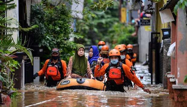 Volunteers evacuate elderly women with an inflatable boat in an area affected by floods, following heavy rains in Jakarta, Indonesia. Antara Foto/Sigid Kurniawan/ via REUTERS