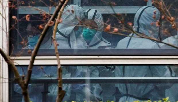 Members of the World Health Organization (WHO) team, tasked with investigating the origins of the coronavirus disease, don personal protection suits during a visit at the Hubei Animal Epidemic Disease Prevention and Control Center in Wuhan, Hubei province, China