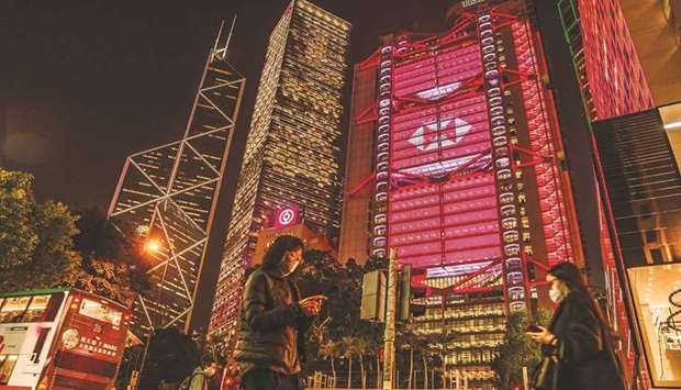 Pedestrians pass the illuminated HSBC Holdings headquarters at night in Hong Kong. HSBC is considering the return of some global leaders to the banku2019s original hometown, reinforcing Asiau2019s role as its centre of gravity.