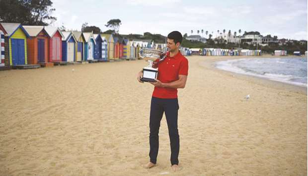 Serbiau2019s Novak Djokovic poses with the Norman Brookes Challenge Cup trophy during a photo shoot at the Brighton Beach in Melbourne yesterday.
