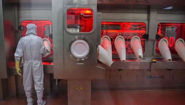 An employee in protective gear works on an assembly line for manufacturing vials of Covishield, AstraZeneca-Oxford's Covid-19 coronavirus vaccine at India's Serum Institute in Pune on January 22.