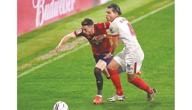 Sevillau2019s Karim Rekik (right) vies for the ball with Osasunau2019s Kike Barja during the La Liga match in Pamplona, Spain, on Monday night. (AFP)