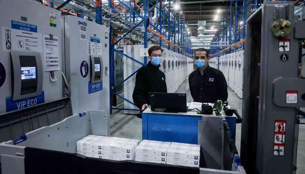 Pfizers employees work at packaging line of the factory of US multinational pharmaceutical company Pfizer in Puurs