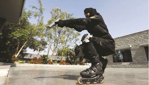 An SSU police officer holds up her weapon as she rollerblades during practice at the headquarters in Karachi.