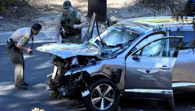 Los Angeles County Sheriff's Deputies inspect the vehicle of golfer Tiger Woods, who was rushed to hospital after suffering multiple injuries, after it was involved in a single-vehicle accident in Los Angeles, California
