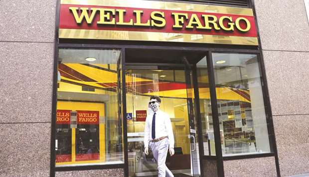 A pedestrian walks out of a Wells Fargo & Co bank branch in New York. GTCR LLC and Reverence Capital Partners agreed to buy Wells Fargo Asset Management for $2.1bn, according to a statement yesterday.