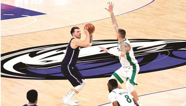 Dallas Mavericks guard Luka Doncic (77) scores over Boston Celtics center Daniel Theis (27) during the fourth quarter at American Airlines Center. (USA TODAY Sports)