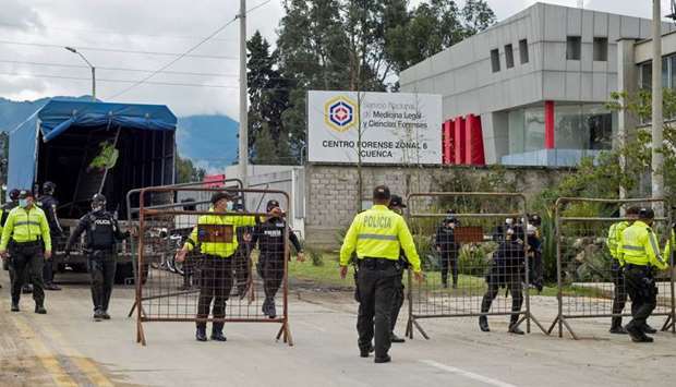 Police set up barricades outside the offices of the Forensic Medicine and Forensic Science institute after the bodies of several inmates were brought in in Cuenca
