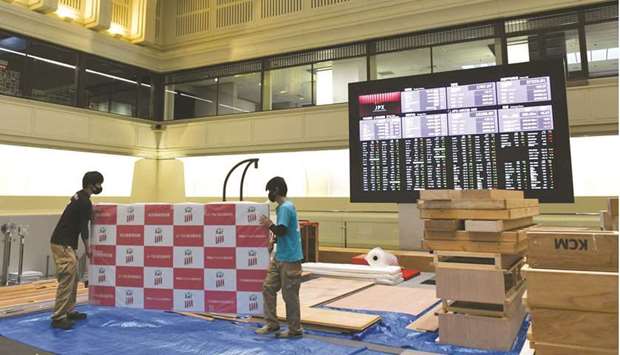 Workers removing a backdrop following a news conference at the Tokyo Stock Exchange. The Nikkei 225 closed 1.7% up at 30,168.27 points yesterday.