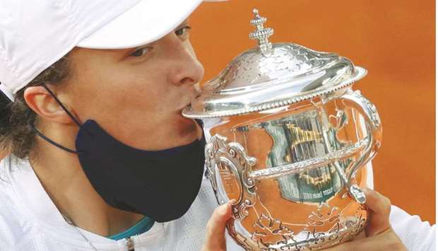In this October 10, 2020, picture, Polandu2019s Iga Swiatek kisses the trophy as she celebrates winning the French Open at Roland Garros in Paris, France. (Reuters)