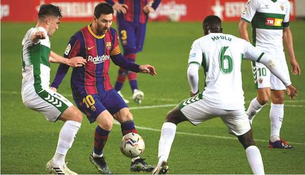Barcelonau2019s Lionel Messi (centre) vies for the ball with Elcheu2019s Raul Guti (left) and Omenuke Mfulu during the La Liga match at the Camp Nou stadium in Barcelona. (AFP)