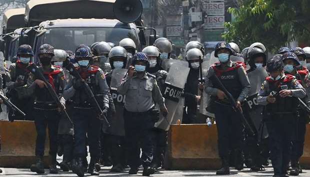 Riot police march on a road to clear away protesters from holding a demonstration against the military coup in Yangon