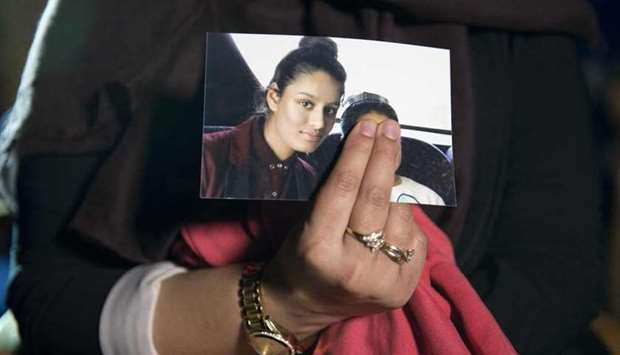 In this file photo taken on February 22, 2015 Renu, eldest sister of British girl Shamima Begum, holds a picture of her sister while being interviewed by the media in central London.