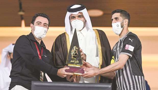HE the President of the Qatar Olympic Committee Sheikh Joaan bin Hamad al-Thani presents the Qatar Cup trophy to Al Sadd captain Hassan al-Haydos (right) and coach Xavi Hernandez (left) yesterday. Al Sadd won the Qatar Cup title for the second time in a row and eighth time overall after beating Al Duhail 2-0 in the final at the Abdullah bin Khalifa Stadium. PICTURE: Noushad Thekkayil
