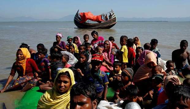 (file photo) Rohingya refugees sit on a makeshift boat after crossing the Bangladesh-Myanmar border, at Shah Porir Dwip near Cox's Bazar