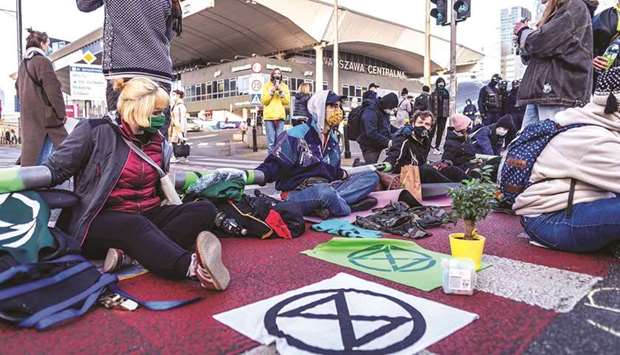 Activists of Extinction Rebellion (XR) environmentalist group form a chain yesterday as they block one of the main streets in the Warsaw city centre to draw public attention to the climate crisis and global warming.