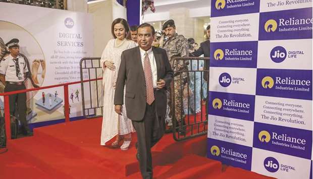Mukesh Ambani, right, and his wife Nita Ambani arrive for the companyu2019s annual general meeting in Mumbai (file). Ambani has focused on pivoting his empire to tech and e-commerce, moving away from energy. Last year, he sold stakes in Relianceu2019s digital and retail units worth $27bn to investors including Google and Facebook, lifting his fortune by $18bn.