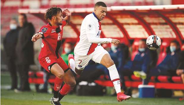 Paris St Germainu2019s Kylian Mbappe (right) vies for the ball with Dijonu2019s Sacha Boey during the Ligue 1 match yesterday. (Reuters)