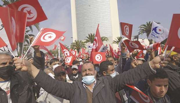 Supporters of the Ennahdha party wave national and party flags during a demonstration in support of the Tunisian government, in the capital Tunis, yesterday.