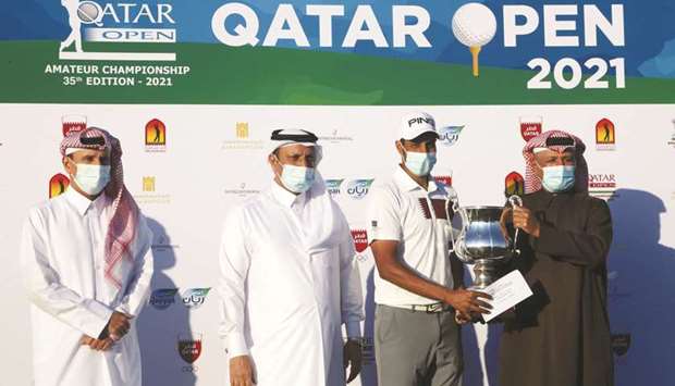 QGA Secretary General Fahad al-Naimi presents the winneru2019s trophy to Qataru2019s Ali al-Shahrani after he won the Qatar Open Amateur Championship at Doha Golf Club yesterday.