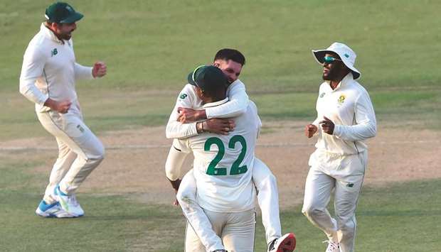 South Africau2019s Keshav Maharaj (centre-top) celebrates with teammates after the dismissal of Pakistanu2019s captain Babar Azam (not in the picture) during the first day of the first Test match at the National Stadium in Karachi.