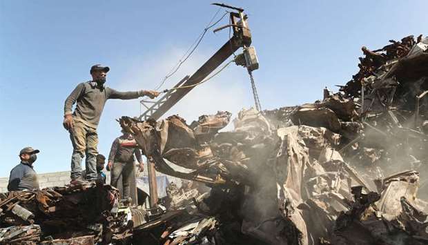 Palestinian workers sort scrap metals to be pressed in preparation for exports, at a scrap yard, east of Gaza City.