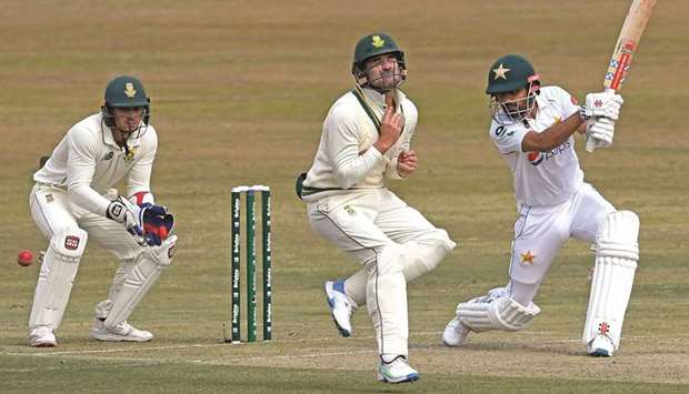 Pakistanu2019s Babar Azam (right) plays a shot past South Africau2019s Dean Elgar (centre) as latteru2019s teammate Quinton De Kock looks on on the first day of the second Test in Rawalpindi, Pakistan, yesterday. (AFP)