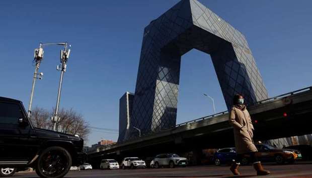 A woman wearing a face mask following the coronavirus disease outbreak walks past the CCTV headquarters, the home of Chinese state media outlet CCTV and its English-language sister channel CGTN, in Beijing, China