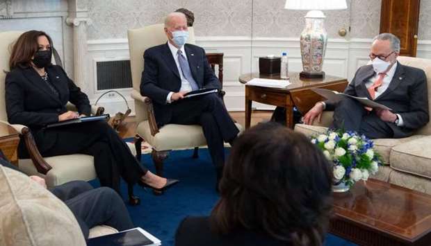 US President Joe Biden hosts a meeting alongside US Vice President Kamala Harris (L), with Senate Democrats, including Senate Majority Leader Chuck Schumer (R), as they meet about a Covid relief bill in the Oval Office of the White House in Washington, DC on February 3.
