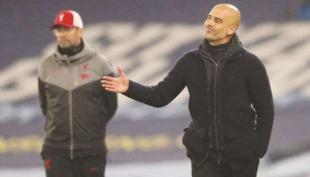 File photo of Manchester City manager Pep Guardiola (R) with Liverpool counterpart Juergen Klopp.
