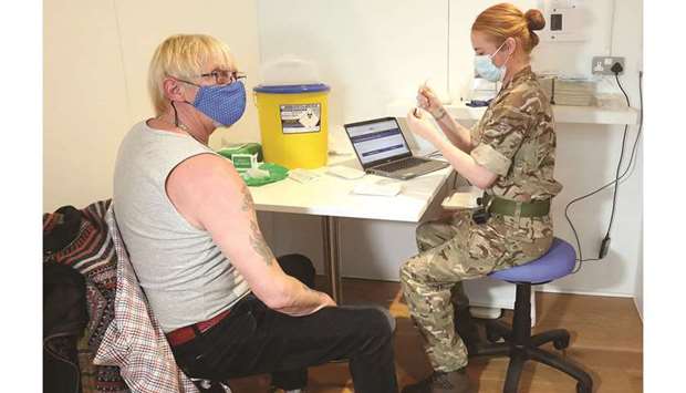 Lance corporal Amy Portman prepares to administer a Covid-19 vaccine to Edinburgh resident Michael Maddocks at a temporary vaccination centre set up at the Royal Highland Showground near Edinburgh, Scotland, as more than 200 military personnel support the vaccination rollout across Scotland.
