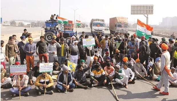 Farmers take part in a three-hour u201cchakka jamu201d or road blockade, as part of protests against farm laws on a highway on the outskirts of New Delhi, yesterday.