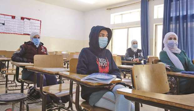 Jordanian pupils wearing protective face masks attend class for the first time in nearly a year, in the capital Amman, yesterday.