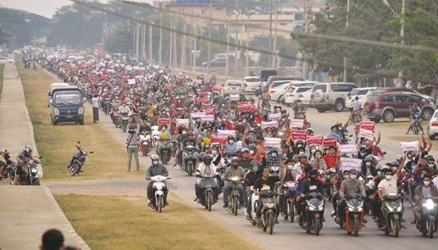 Protesters ride scooters in a large convoy demonstration against the military coup in Naypyidaw yesterday.