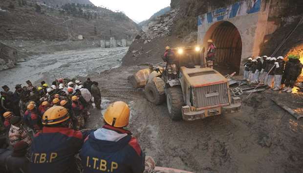 Members of Indo-Tibetan Border Police (ITBP) watch as a machine is used to clear a tunnel after a part of a glacier broke away, in Tapovan in the northern state of Uttarakhand, India, yesterday.