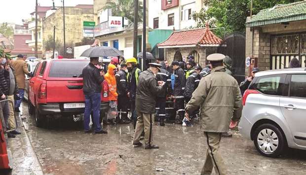 Emergency services gather at the site of an illegal underground textile workshop that flooded after heavy rainfall in Moroccou2019s city of Tangiers, yesterday.