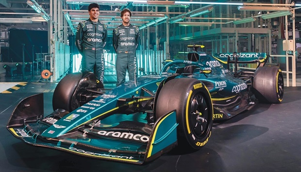 A handout picture released by Aston Martin shows their F1 drivers Lance Stroll and Sebastian Vettel (right) posing with the new AMR22 car during its presentation at the global headquarters of Aston Martin Lagonda in Gaydon, England, yesterday. (AFP)