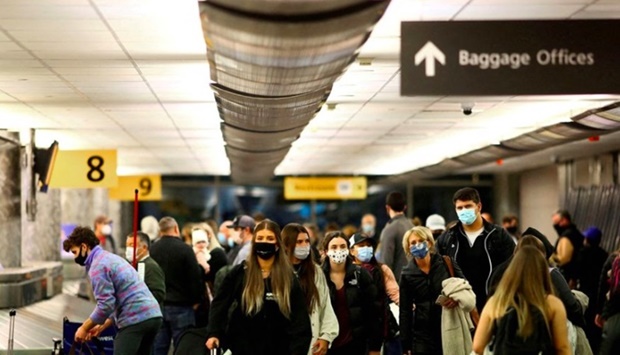 Travellers wearing protective face masks to prevent the spread of the coronavirus disease (Covid-19) reclaim their luggage at the airport in Denver, Colorado, U.S. November 24, 2020. 