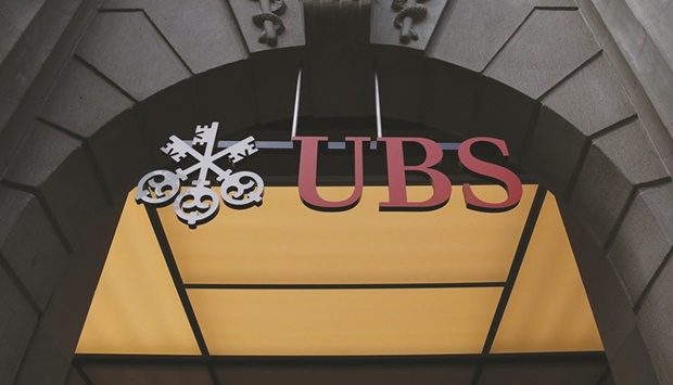A sign hangs above the entrance to the UBS Group headquarters in Zurich. UBS surged to the highest level in four years after the bank surprised analysts by pledging to buy back as much as $5bn of shares and posted ambitious profit and cost targets