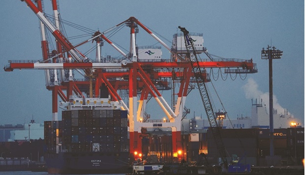 A cargo ship and containers are seen at an industrial port in Tokyo. The worldu2019s third-largest economy expanded an annualised 5.4% in October-December after contracting a revised 2.7% in the previous quarter, government data showed on Tuesday, falling short of a median market forecast for a 5.8% gain.