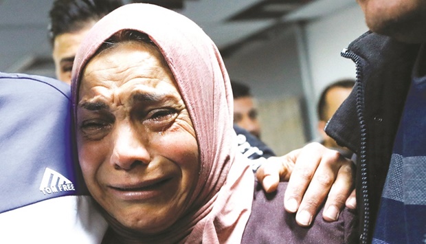 Mother of the Palestinian cries next to his body, who medics said was shot by Israeli forces during clashes, at a hospital near Ramallah in the occupied West Bank, yesterday.