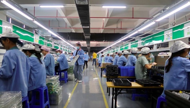 Employees work on the production line of RiotPWR mobile gaming controllers for U.S. company T2M, at a factory in Dongguan, Guangdong province, China December 7, 2021. Picture taken December 7, 2021.