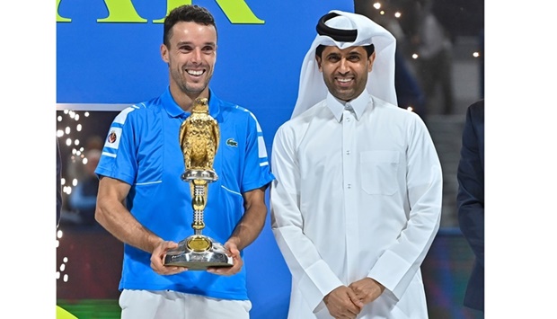 Roberto Bautista Agut of Spain (L) poses with the championship trophy and with Nasser al-Khelaifi (R), president of the Qatar Tennis Federation, Paris Saint-Germain FC, and chairman of beIN Media Group; after winning the tennis final match of the 2022 ATP Qatar Open against Nikoloz Basilashvili of Georgia in Doha. PICTURES: Noushad Thekkayil